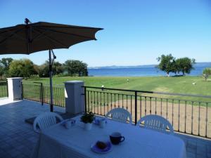 a table and chairs with an umbrella on a balcony at Azienda Agricola Melona in Bolsena