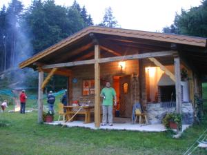 a woman standing in front of a small cabin at Lochgrubgut in Altenmarkt im Pongau