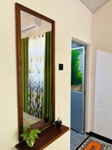 a mirror on a wall next to a door at jungle view in Nilwella