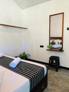 a bedroom with a bed with a mirror and a stool at jungle view in Nilwella
