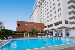 a hotel with a swimming pool in front of a building at Art Hotel Kagoshima in Kagoshima