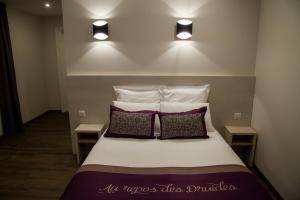 een slaapkamer met een bed met 2 kussens en 2 verlichting bij The Originals City, le Relais des Carnutes Brezolles Verneuil sur Avre in Brezolles