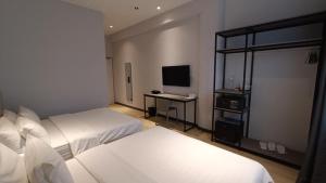 a hotel room with two beds and a television at Macalister 288 in George Town