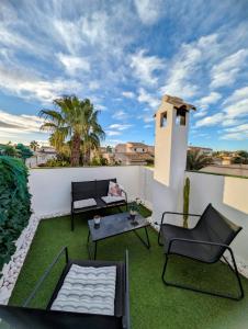 a patio with a table and chairs on a roof at Relaxing & Cozy House in Gran Alacant