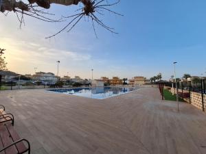a swimming pool in a park with a wooden deck at Relaxing & Cozy House in Gran Alacant