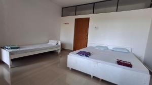 two beds in a room with a door at Rooms In Canacona in Canacona