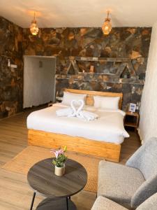 a bedroom with a bed and a table at Panorama Guest House Jabal Shams in Sa‘ab Banī Khamīs +13 photos