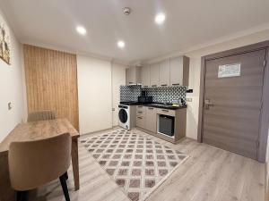 a kitchen with a table and a stove and a door at Rena Grand Residence & Suit in Trabzon