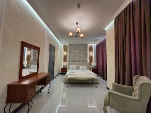a bedroom with a bed and a mirror and a desk at Khazri Resort & Villas in Baku