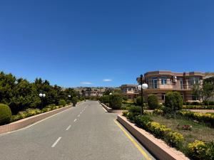 an empty street in a residential neighborhood with houses at Khazri Resort & Villas in Baku