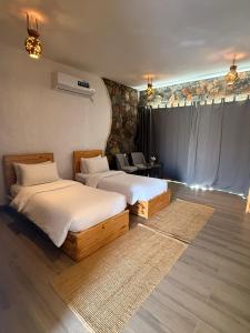 a room with two beds and a table and chairs at Panorama Guest House Jabal Shams in Sa‘ab Banī Khamīs