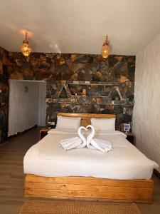 a bedroom with a bed with a ribbon on it at Panorama Guest House Jabal Shams in Sa‘ab Banī Khamīs