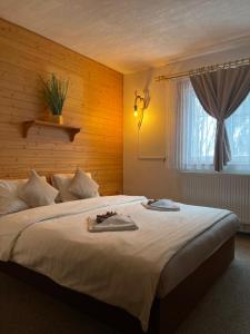 a bedroom with a large white bed with a window at Pension MÍŠA in Velká Úpa +40 photos