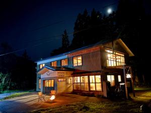 a building with lights on at night at 静かな森の古民家ステイ Tunagiつなぎ in Nishiwaga
