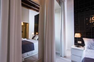 a bedroom with a bed and a mirror at LuxurYenne in Cagliari