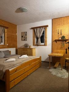 a bedroom with a wooden bed and a table at Pension MÍŠA in Velká Úpa