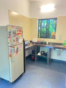 a kitchen with a desk and a refrigerator in a room at Casa de sazu 1bhk in Mandrem +8 photos