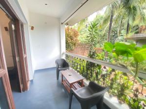 a balcony with two chairs and a table at Casa de sazu 1bhk in Mandrem