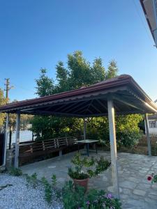 a pavilion with a picnic table and a bench at Muğladaki Eviniz in Muğla