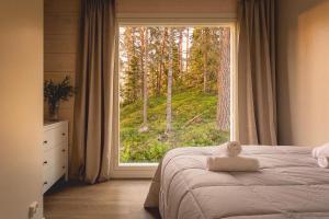 a bedroom with a bed and a large window at Stay North - Harmonia in Halslahti