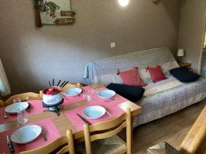 a room with a dining table and a bed at Appartement residence bec aigle in Le Lioran