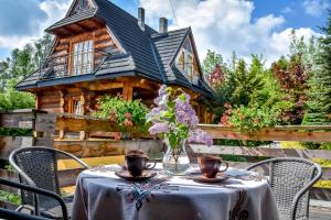 a table in front of a log cabin at Willa Anna Bukowina Jacuzzi & Sauna in Bukowina Tatrzańska
