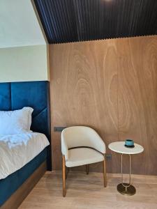 a bedroom with a bed and a chair and a table at refleXions in Kabakelis