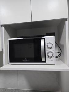 a microwave sitting on a shelf in a kitchen at Apartamento Céntrico y Equipado in Concepción +5 photos