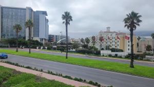 a car driving down a road with palm trees and buildings at El Roi on NINE PALMS in Cape Town