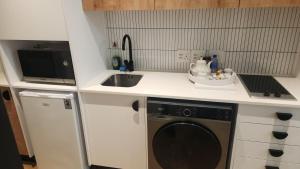 a kitchen with a washing machine and a sink at El Roi on NINE PALMS in Cape Town