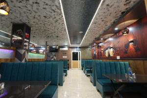 a dining room with blue chairs and tables at Elixir Boarding & Lodging in Bangalore