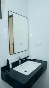 a bathroom with a sink and a large mirror at Tam coc Sylvani Homestay in Vũ Lâm