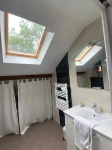 a bathroom with a sink and a mirror at Chez Rose-Laure in Grandviala