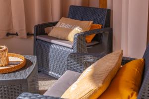 a room with wicker chairs and tables with pillows at PV9 by DomusAway in Olbia +3 photos