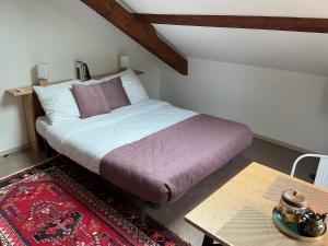 a bedroom with a bed and a table with a coffee table at Chez Rose-Laure in Grandviala