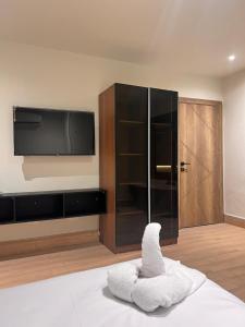 a room with a tv and a stuffed animal on a bed at King's Gate Pyramids Horizon in Cairo