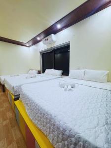 two beds in a room with white sheets at Tam coc Sylvani Homestay in Vũ Lâm