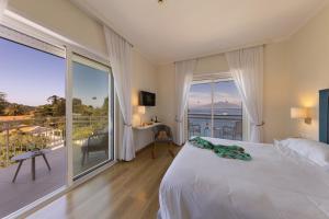 a bedroom with a white bed and a large window at Boutique Hotel Regina in Sorrento +155 photos