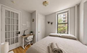 a bedroom with a bed and a desk and a window at The NYC Value Room near Times Square & Broadway - Private Room with shared bathroom in New York