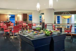 a buffet in a hotel lobby with tables and chairs at Mercure Jakarta Kota in Jakarta