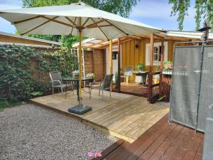 a patio with a table and an umbrella at Lilla Stugan, Sjötorp in Sjötorp