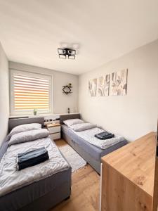 a bedroom with two beds and a table at Apartament Ryki in Ryki