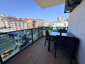 a balcony with a table and chairs and a view of a city at Rena Grand Residence & Suit in Trabzon