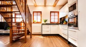 a kitchen with white cabinets and a spiral staircase at Apartment in Žatec in Žatec