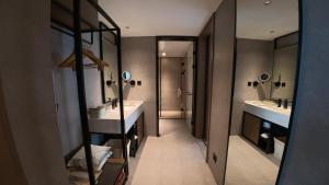 a bathroom with two sinks and a walk in shower at Atour Hotel Karamay in Karamay +26 photos