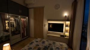 a bedroom with a bed and a window with a television at RR Travertine House Cikarang in Jatirarangan