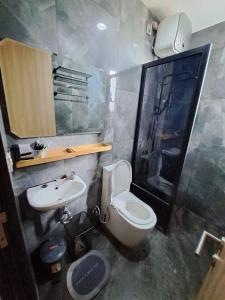 a bathroom with a white toilet and a sink at RR Travertine House Cikarang in Jatirarangan +7 photos