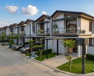 a row of houses with cars parked in a parking lot at RR Travertine House Cikarang in Jatirarangan