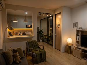 a living room with a teddy bear sitting on a couch at RR Travertine House Cikarang in Jatirarangan