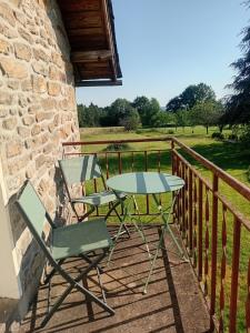 a table and two chairs on a balcony at Appartement en Corrèze in Le Lonzac